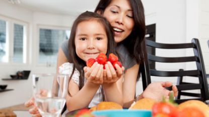 Mother and daughter happy eating fruit